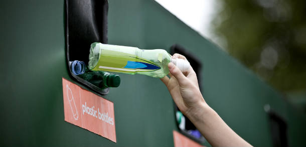 A resident recycling a plastic bottle.