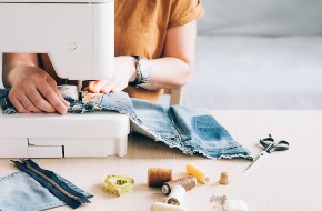 Repairing jeans with a sewing machine.