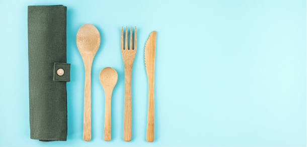 Reusable bamboo cutlery and case with a blue background.