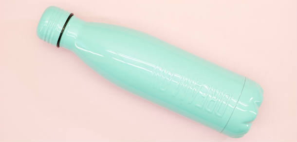 Blue reusable water bottle with pink background.