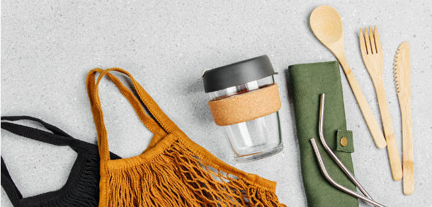 Reusable shopping bags, glass KeepCup, reusable metal straws and wooden cutlery.