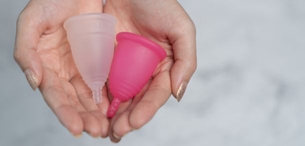 Hands holding two menstrual cups