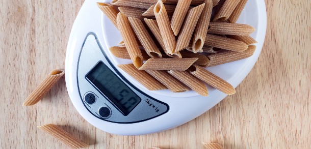 Dried wholemeal pasta in a set of electronic scales.