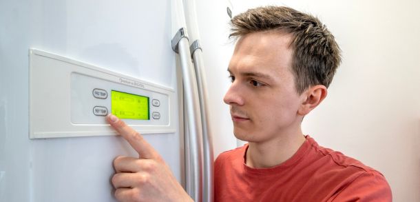 Man regulating the temperature on his fridge.