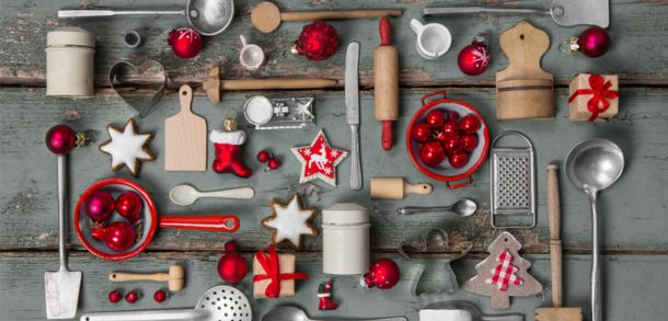 Christmas kitchen tools hanging on a grey wall.