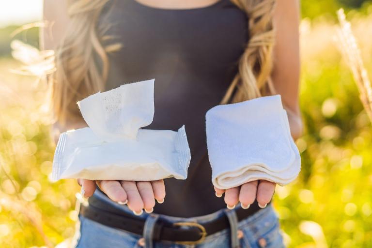 Lady holding reusable wipes in one hand and cloth wipes in other.