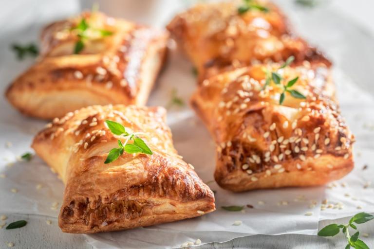 Apple, cheddar and walnut sausage rolls on a plate.