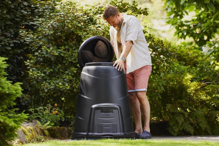 Man in shorts looking in a compost bin