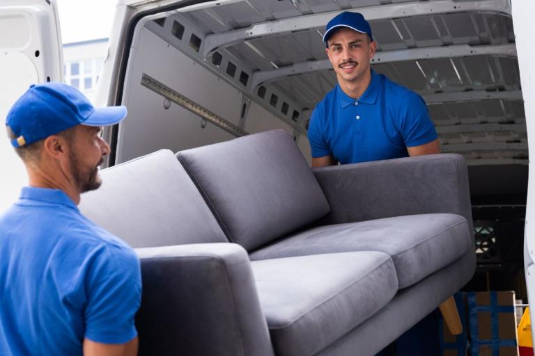 Sofa being loaded into the back of a van.