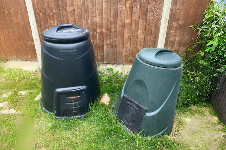 Two dalek style compost bins in garden.