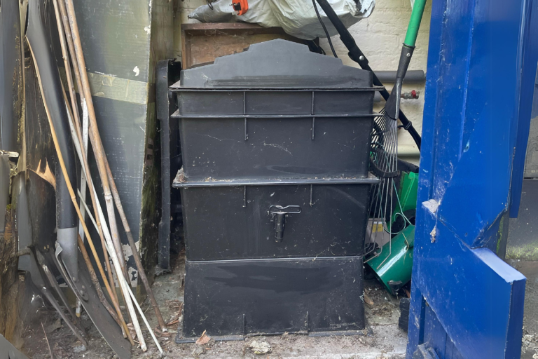 A black wormery in a garage.